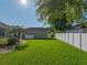 Sprawling backyard featuring lush green grass, white fencing, and mature trees at 152 Melissa Trl, Auburndale, FL 33823