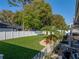 Spacious backyard with lush lawn, elegant landscaping, and partial view of the screened pool area at 152 Melissa Trl, Auburndale, FL 33823