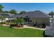 View of the backyard showing the pool, screened enclosure, landscaping, and the home's well maintained exterior at 152 Melissa Trl, Auburndale, FL 33823
