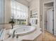 Bright bathroom with tub, shower, large window, decorative features and toilet room at 152 Melissa Trl, Auburndale, FL 33823
