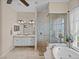 Bright bathroom featuring double sinks, walk in shower, soaking tub and large window at 152 Melissa Trl, Auburndale, FL 33823