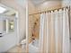 Tiled bathroom features a shower-tub combination, a door to outside, and a toilet at 152 Melissa Trl, Auburndale, FL 33823