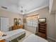 Comfortable bedroom with neutral walls, two beds, carpet floors, ceiling fan and a sunny window with floral curtains at 152 Melissa Trl, Auburndale, FL 33823