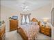 Charming bedroom featuring a wooden bed frame, soft carpet, and natural light from the window with patterned drapes at 152 Melissa Trl, Auburndale, FL 33823