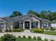 Beautiful beige single-Gathering home with white columns, manicured shrubs, and a circular driveway at 152 Melissa Trl, Auburndale, FL 33823