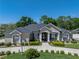 Charming beige single-Gathering home with white columns, manicured shrubs, and a circular driveway at 152 Melissa Trl, Auburndale, FL 33823