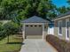 A detached garage with a neutral color scheme and complementing landscaping in the front yard at 152 Melissa Trl, Auburndale, FL 33823