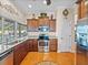 Traditional kitchen featuring stainless steel appliances, cherry wood cabinets, and hardwood floors at 152 Melissa Trl, Auburndale, FL 33823