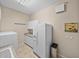 Bright laundry room featuring a washer, dryer, fridge, and storage cabinets for efficient organization at 152 Melissa Trl, Auburndale, FL 33823