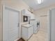 Functional laundry room equipped with a washer, dryer, sink, and storage cabinets for convenience at 152 Melissa Trl, Auburndale, FL 33823