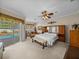 Spacious main bedroom with ceiling fan, sitting area, and sliding glass doors to the outdoor pool area at 152 Melissa Trl, Auburndale, FL 33823