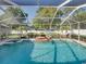 The screened-in pool features a rock waterfall, a spa, and landscaped surroundings at 152 Melissa Trl, Auburndale, FL 33823