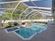 Enclosed pool featuring a rock waterfall, spa, and lush green landscaping around the area at 152 Melissa Trl, Auburndale, FL 33823