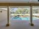 Exterior shot of an enclosed pool with rock waterfall feature and mature, lush landscaping at 152 Melissa Trl, Auburndale, FL 33823