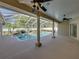 Covered outdoor patio features a swimming pool, hot tub, ceiling fans, and travertine tile at 152 Melissa Trl, Auburndale, FL 33823