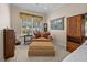 Comfortable sitting area with window and blinds, decorative tapestry, lamp, and plush chair and ottoman at 152 Melissa Trl, Auburndale, FL 33823
