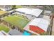 Aerial view of a home featuring a lush, green lawn, a covered patio, and a detached red-colored storage unit at 1619 Salesberry St, Lakeland, FL 33803