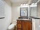 Bathroom featuring a granite countertop, wooden cabinetry, decorative mirror, and tiled shower at 2605 Nevada Rd, Lakeland, FL 33803