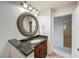 Bathroom vanity with granite countertop and decorative mirror, open doorway to a bedroom in the background at 2605 Nevada Rd, Lakeland, FL 33803
