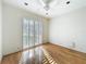 Bright bedroom featuring hardwood floors, a ceiling fan, and shuttered windows at 2605 Nevada Rd, Lakeland, FL 33803