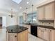 A well-lit kitchen with an island, granite countertops, and views of the backyard at 2605 Nevada Rd, Lakeland, FL 33803