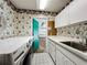 Functional laundry room with floral wallpaper, utility sink and easy access to the garage at 2605 Nevada Rd, Lakeland, FL 33803