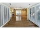 Open-concept living room with shuttered windows, beamed ceilings, and gleaming hardwood floors at 2605 Nevada Rd, Lakeland, FL 33803