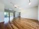 Spacious living room featuring hardwood floors, a skylight, a ceiling fan, and large sliding glass doors leading to the pool at 2605 Nevada Rd, Lakeland, FL 33803