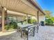 A covered outdoor patio featuring a dining table and lush landscaping at 2605 Nevada Rd, Lakeland, FL 33803