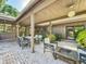 Covered brick patio featuring a dining table, chairs, a loveseat, a coffee table, and a fire pit at 2605 Nevada Rd, Lakeland, FL 33803