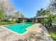 Backyard oasis showcasing a refreshing in-ground pool with a brick surround, lush greenery, and patio at 2605 Nevada Rd, Lakeland, FL 33803