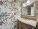 Charming powder room with floral wallpaper, marble countertop and decorative mirror at 2605 Nevada Rd, Lakeland, FL 33803