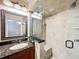 Bathroom showcasing tiled shower with glass partition, granite countertop, and decorative mirror at 2605 Nevada Rd, Lakeland, FL 33803