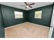 A bedroom boasts dark green walls, carpet and is brightened by two windows at 2735 Aldine Cir, Lakeland, FL 33801