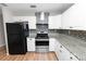 Modern kitchen with white cabinetry, granite countertops and stainless steel appliances at 2735 Aldine Cir, Lakeland, FL 33801