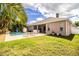 Beautiful backyard featuring a sparkling pool, spa, patio seating, and lush tropical landscaping at 2814 Sheldon St, Lakeland, FL 33813