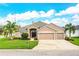 Charming home featuring a stone accent façade, a three-car garage, lush lawn, and mature palm trees at 2814 Sheldon St, Lakeland, FL 33813