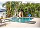 Inviting backyard pool area with mosaic tile accents, a slide, and lush tropical foliage for privacy at 2814 Sheldon St, Lakeland, FL 33813