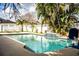 Backyard oasis with a pool featuring mosaic tile accents, tropical foliage, and outdoor seating at 2814 Sheldon St, Lakeland, FL 33813