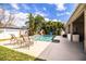 Backyard featuring a pool with mosaic accents, tropical landscaping, and outdoor seating and kitchen area at 2814 Sheldon St, Lakeland, FL 33813