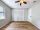 A bedroom featuring wood floors, double door closets and a ceiling fan at 2821 Grapefruit Dr, Auburndale, FL 33823