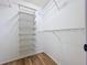 Walk-in closet with custom shelving and hardwood floors for optimal storage at 2821 Grapefruit Dr, Auburndale, FL 33823