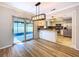 Bright dining area with sliding doors, hardwood floors, modern lighting, and open to the kitchen at 2821 Grapefruit Dr, Auburndale, FL 33823