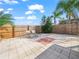 Landscaped backyard featuring a paved area with seating, tropical plants, and a wooden fence at 300 Keswick Ave, Davenport, FL 33897