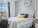 Bright main bedroom with a large window, wood-look floors, and stylish decor at 300 Keswick Ave, Davenport, FL 33897