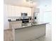 Contemporary kitchen featuring an island, sleek cabinets, and modern appliances at 300 Keswick Ave, Davenport, FL 33897