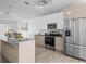 Well-equipped kitchen with a large granite island, stainless steel appliances, and modern cabinetry at 300 Keswick Ave, Davenport, FL 33897