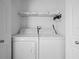 Bright laundry room featuring a washer, dryer, and wire shelving for storage at 300 Keswick Ave, Davenport, FL 33897