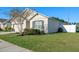 Side of single-story home with a two-car garage, manicured landscaping, and green grass at 301 St Georges Cir, Eagle Lake, FL 33839