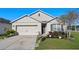 Charming single-story home with a two-car garage, stone-lined walkway, and manicured landscaping at 301 St Georges Cir, Eagle Lake, FL 33839